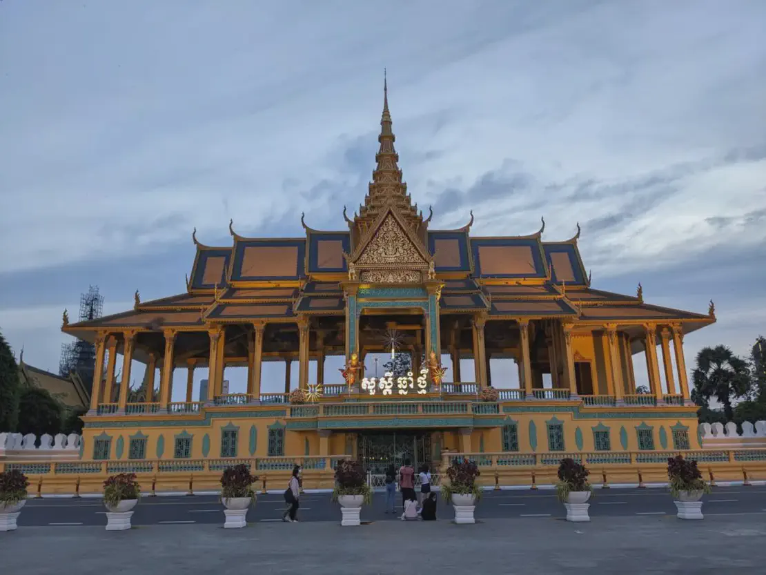 Golden Royal Palace building in Phnom Penh with ornate roof and evening sky backdrop.
