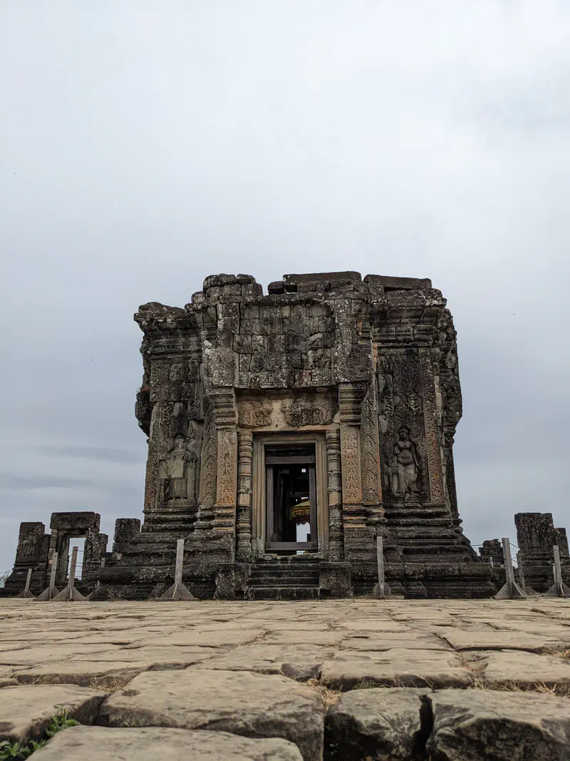 Ancient stone temple entrance with detailed carvings at Angkor complex.