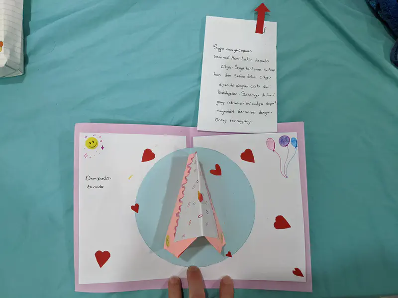Handmade pop-up birthday card decorated with hearts, balloons, and a written message.
