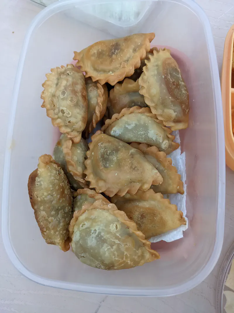 Container filled with fried pastries arranged neatly.