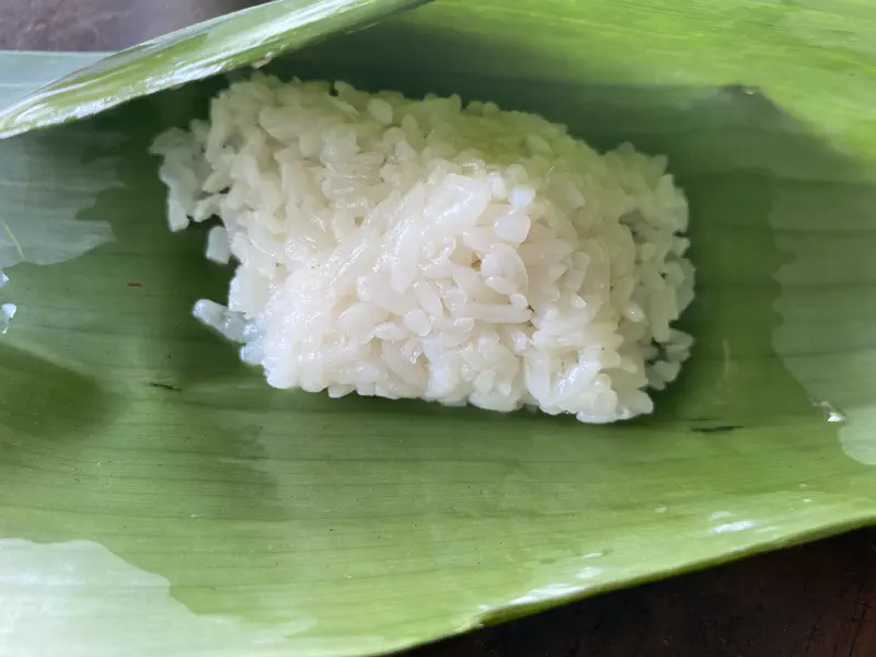 Close-up of fermented rice served on a banana leaf.