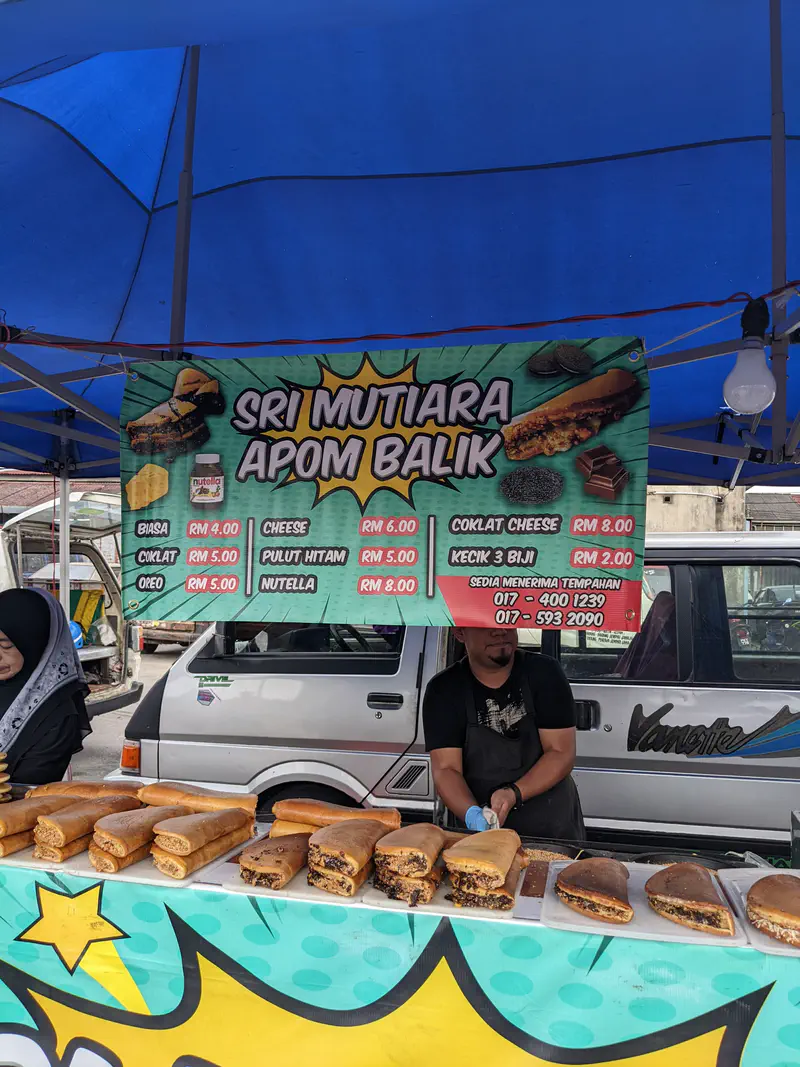 Sri Mutiara Apom Balik stall selling thick peanut-filled pancakes with various flavors such as chocolate, cheese, Oreo, and Nutella.