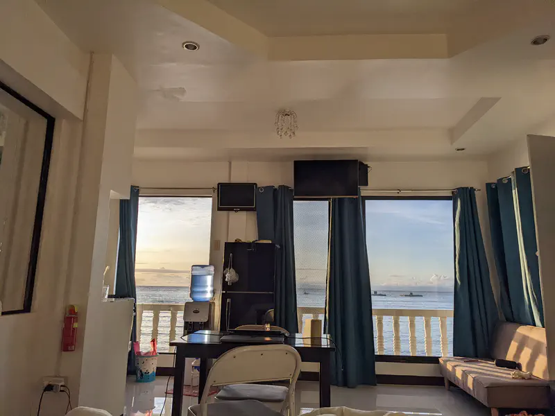 Apartment interior with sunset light shining through windows overlooking the ocean.