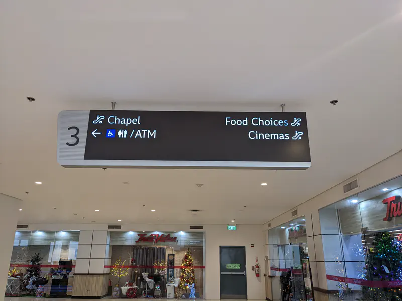 Mall directional sign pointing to chapel, ATM, food choices, and cinemas.