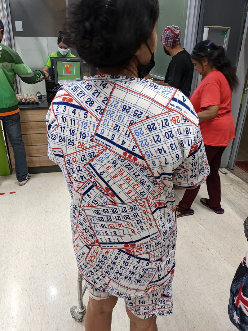 Person inside a store wearing a shirt covered in calendar date patterns while waiting in line.