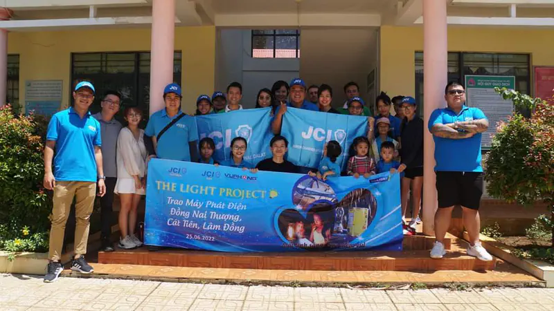 Group of people posing with a banner for The Light Project in Đồng Nai Thượng.