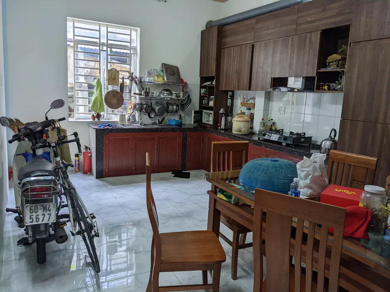 Kitchen with wooden cabinets, a dining table, and a motorcycle parked inside.