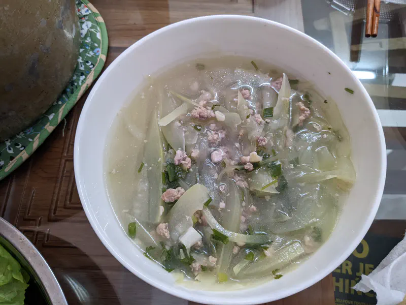 Bowl of light Vietnamese soup with winter melon, minced pork, and green onions.