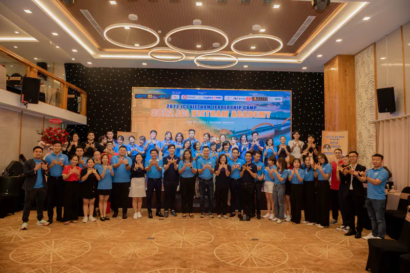 Large group posing together in front of a banner for the 2022 JCI Vietnam Academy.
