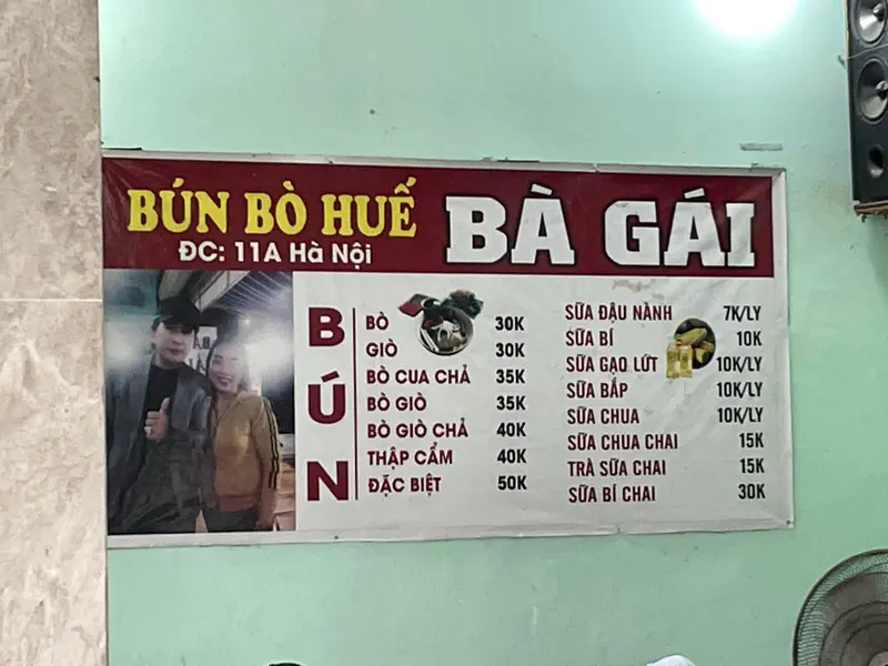 Restaurant menu board for Bún Bò Huế Bà Gái with food and drink prices listed.