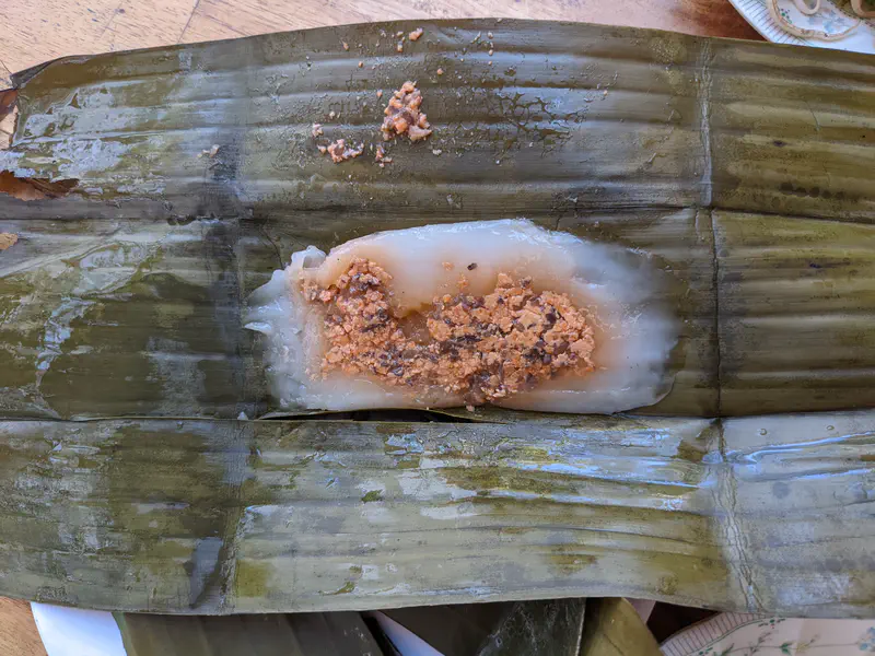 Steamed Vietnamese rice dumpling with bean filling served on a banana leaf.